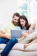 © WavebreakmediaMicro - Couple using digital tablet in living room