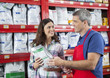 © Tyler Olson - Customer Looking At Salesman While Receiving Pet Food From Him