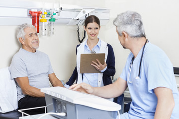 Canvas Print - Physiotherapist And Patient Looking At Doctor In Rehab Center