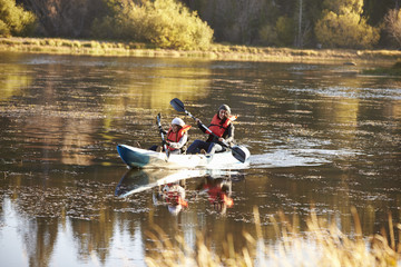 Wall Mural - Mother and daughter kayaking together on a lake, front view