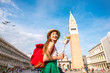 Young female traveler having fun with carnaval mask standing on San Marco square in Venice.