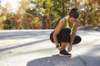 © Monkey Business - Woman ties her sports shoe before a run, looking down