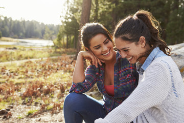 Wall Mural - Happy lesbian couple laughing together in the countryside