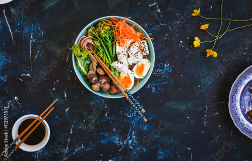Fotoboard na płycie Asian miso ramen makaron z jajkiem, tofu, wieprzowiną i enoki w misce na niebieskim marmurowym stole.