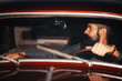 © endrews21 - brutal bearded man with a smart mustache brunette sitting in a dark saloon car retro evening at sunset
