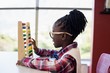 © WavebreakMediaMicro - Schoolgirl using a math abacus in classroom