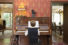 A Boy Practicing On An Old-fashioned Upright Piano