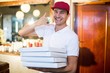 © WavebreakMediaMicro - Pizza delivery man holding pizza boxes making a phone gesture