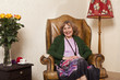 © fStop - A senior woman sitting in an armchair in her living room