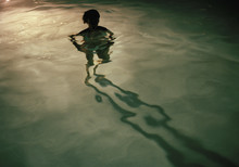 A Young Woman Standing In A Swimming Pool At Night, Silhouette