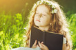 Little girl closed her eyes, praying, dreaming or reading a book