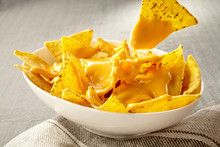 Chip Pulled Out Of Bowl Of Cheese Covered Nachos