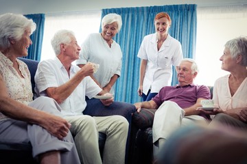 Wall Mural - Group of seniors interacting with nurse