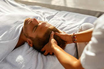 Spa Massage. Closeup Of Beautiful Healthy Happy Man Enjoying Relaxing Head Massage At Outdoor Day Salon. Masseur Hands Massaging Handsome Male Head. Relax Beauty Treatment For Men, Health Care Concept