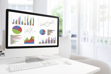 modern computer with keyboard and mouse on table showing charts