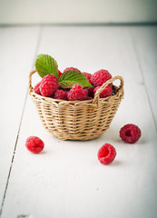 Poster - Ripe fresh raspberries with leaves in a basket