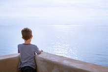 Child Looking At The Sparkling Sea Water