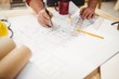 © Wavebreak Media - Carpenter drawing on a plan with a compass