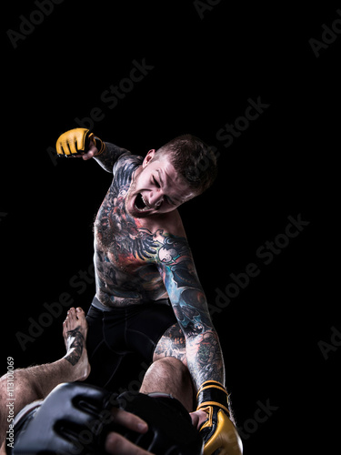 Zdjęcie XXL Agresywny wojownik MMA bije przeciwnika na ziemię