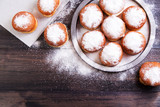 Fototapeta  - German donuts - berliner with jam and icing sugar in a tray on a wooden background. Top view