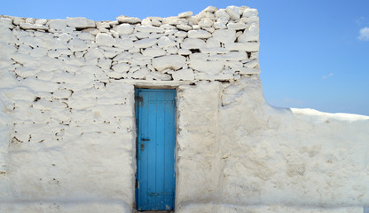 Old painted blue door on the whitewashed wall