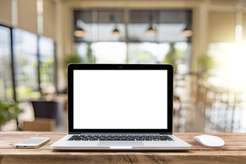 Laptop with blank screen on table of a cafe