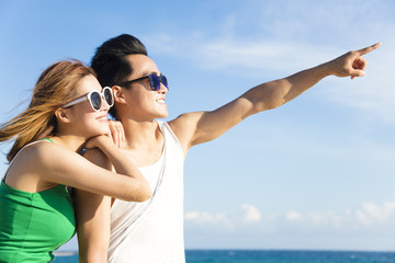 Wall Mural - Happy young Couple looking at view  on the Beach