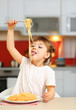 © Africa Studio - Adorable little girl eating spaghetti at table