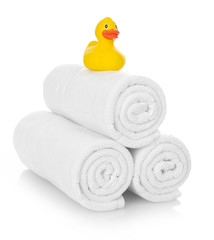 Rubber duck on white towels