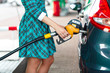 © vladstar - Woman fills petrol into the car at a gas station