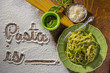 Overhead View of Floured Table and Handwriting with Plate of Fettuccine and Pesto