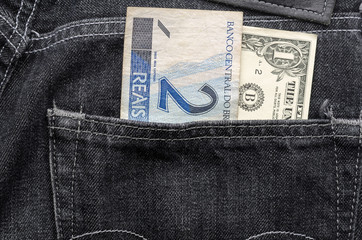 Wall Mural - One dollar and two brazilian money inside jeans pocket