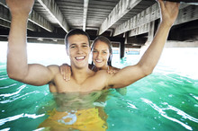 Couple Swimming Under Pier At Lake