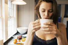 Woman Drinking Coffee In The Kitchen