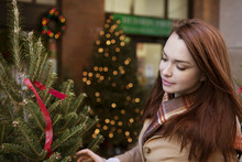Young Woman Looking At Christmas Tree