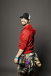 © Cavan Images - Portrait of smiling rock climber with various hooks standing against gray background