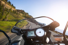 Cropped Image Of Motorcycle Moving On Mountain Road Against Clear Sky