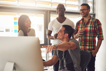 Man showing something on computer to happy friends