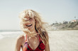 © Cavan Images - Smiling blond young woman enjoying beach