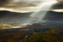 Scenic View Of Sunlight Streaming Through Cloudy Sky Over Mountain