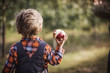 © Cavan Images - Rear view of a boy holding eaten apple