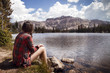 © Cavan Images - Rear view of woman sitting near lake