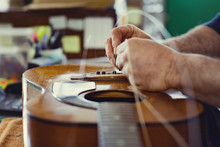 Man Changing Strings On Guitar