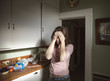 © Cavan Images - Stressed young woman standing in kitchen