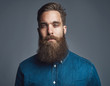 Bearded man in blue denim with tired expression