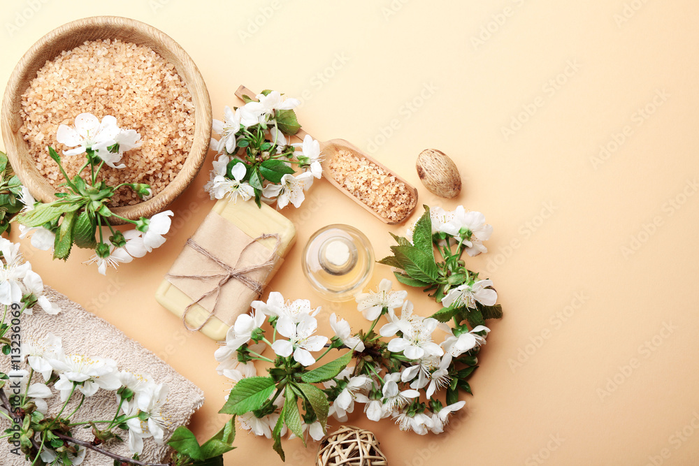 Spa treatment with blooming branch on beige background
