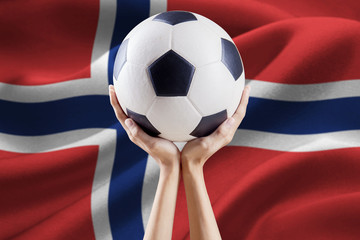 hands holding ball with flag of norway