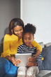 © Flamingo Images - Little black girl and mom with tablet