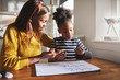 © Flamingo Images - Black mom and child doing homework