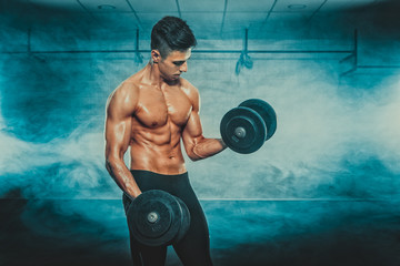 Portrait of young fit man with dumbbell